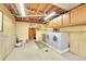 Unfinished basement with exposed ceiling, laundry area, and washer and dryer at 3145 S Bryant St, Englewood, CO 80110
