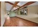 Open living area featuring exposed wood beams, hardwood floors, and a wall of windows for natural light at 3145 S Bryant St, Englewood, CO 80110