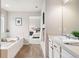 Bright bathroom with tub and a view into the main bedroom at 17949 W 94Th Dr, Arvada, CO 80007
