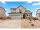 Charming two-story home featuring a manicured front yard, two-car garage, and solar panels on the roof at 17949 W 94Th Dr, Arvada, CO 80007