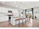 Bright open kitchen with stainless steel appliances, island seating, and hardwood floors at 17949 W 94Th Dr, Arvada, CO 80007