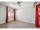 Spacious bedroom with new floors, ceiling fan and bright window with decorative red curtains at 857 S Van Gordon Ct # B107, Lakewood, CO 80228
