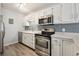 Updated kitchen features stainless steel appliances, a gray backsplash and bright, white cabinets at 857 S Van Gordon Ct # B107, Lakewood, CO 80228