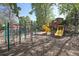 A colorful playground with slides and climbing equipment sits on a mulch surface with trees at 857 S Van Gordon Ct # B107, Lakewood, CO 80228