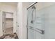 Bathroom with a glass-enclosed shower, tiled floor, and access to the walk-in closet at 1888 Ruby Ct, Brighton, CO 80603