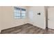 A well-lit bedroom with vinyl floors, a large window, and a door at 1888 Ruby Ct, Brighton, CO 80603