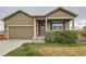 Inviting home exterior with a well-maintained lawn, covered porch, and attached two-car garage at 1888 Ruby Ct, Brighton, CO 80603