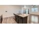 Modern kitchen island with stainless steel appliances and light countertops, connecting to the dining area at 1888 Ruby Ct, Brighton, CO 80603