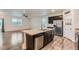 Open kitchen with stainless steel appliances, island with sink, and hardwood floors with an open-concept floorplan at 1888 Ruby Ct, Brighton, CO 80603