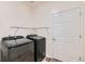 Modern laundry room with washer, dryer, shelving, and a door, providing convenience and storage at 1888 Ruby Ct, Brighton, CO 80603