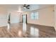 Spacious living room with hardwood floors, a ceiling fan, and sliding glass doors with neutral curtains at 1888 Ruby Ct, Brighton, CO 80603