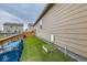 Clean side yard with artificial turf, a wooden fence, and utility access, maximizing outdoor space at 1888 Ruby Ct, Brighton, CO 80603