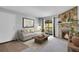 Comfortable living room featuring a stone fireplace, a sofa, and a balcony overlooking the exterior at 4400 S Quebec St # 207L, Denver, CO 80237