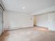 Finished basement area featuring neutral carpeting, white walls and door to the backyard at 2653 S Harrington Ln, Lakewood, CO 80227