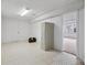 Basement with tile floors, lighting, a door to another room, and a storage unit at 2653 S Harrington Ln, Lakewood, CO 80227