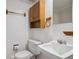Bathroom featuring a toilet, sink, medicine cabinet, towel rack, and toilet paper holder at 2653 S Harrington Ln, Lakewood, CO 80227