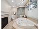 Bright bathroom featuring a cozy fireplace, soaking tub, and a separate shower at 2653 S Harrington Ln, Lakewood, CO 80227