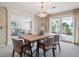 Elegant dining room with modern chandelier, neutral decor, and sliding glass door to the outside at 2653 S Harrington Ln, Lakewood, CO 80227