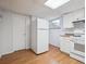 Bright kitchen with white cabinets, appliances, wood flooring and view of backyard at 2653 S Harrington Ln, Lakewood, CO 80227