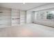 Bright living room featuring built-in shelving, a neutral carpet and three windows for natural light at 2653 S Harrington Ln, Lakewood, CO 80227