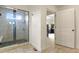 Bathroom showcasing a tiled glass shower and access to the primary bedroom at 16002 E 111Th Cir, Commerce City, CO 80022
