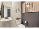 Stylish powder room featuring a pedestal sink, decorative sconces, and unique zebra art on the wall at 16002 E 111Th Cir, Commerce City, CO 80022