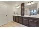 Double vanity bathroom with dark wood cabinetry and tile floors at 16002 E 111Th Cir, Commerce City, CO 80022