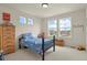 Sunny bedroom with large windows and a blue shark-themed comforter at 16002 E 111Th Cir, Commerce City, CO 80022