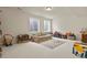 Spacious bonus room featuring neutral carpet, a comfortable couch, and plenty of natural light at 16002 E 111Th Cir, Commerce City, CO 80022