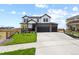 Beautiful two-story home boasting a three-car garage, stone accents, and a manicured lawn at 16002 E 111Th Cir, Commerce City, CO 80022