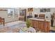Open living room with a stylish wooden desk, rustic decor, and abundant natural light at 16002 E 111Th Cir, Commerce City, CO 80022
