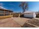 View of driveway leading to a detached garage with a screened-in porch at 3500 W 55Th Ave, Denver, CO 80221