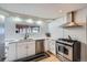 Updated kitchen featuring stainless steel appliances, stylish backsplash, and white cabinetry at 3500 W 55Th Ave, Denver, CO 80221