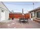 Outdoor patio with a stone walkway, dining set and red wooden fence perfect for enjoying outdoor meals at 2211 Lamar St, Edgewater, CO 80214