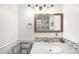 Well-lit bathroom with a stone countertop vanity, decorative backsplash, and a framed mirror above the sink at 2211 Lamar St, Edgewater, CO 80214