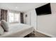 Bedroom featuring a bed with white comforter and an mounted flatscreen television at 2211 Lamar St, Edgewater, CO 80214
