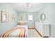 Light-filled bedroom with soft blue walls and rainbow themed bedspread, with a white dresser at 2211 Lamar St, Edgewater, CO 80214