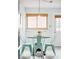 Bright breakfast nook with round table and four turquoise chairs, and light-colored walls at 2211 Lamar St, Edgewater, CO 80214