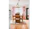 Inviting dining room with wooden table and chairs, bright patterned curtains, chandelier and hardwood floors at 2211 Lamar St, Edgewater, CO 80214