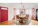 Bright dining room with a large wooden table, seating for eight, and eye-catching floral curtains at 2211 Lamar St, Edgewater, CO 80214