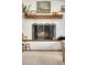 Close up of the fireplace with white painted brick and a decorative screen at 2211 Lamar St, Edgewater, CO 80214