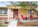 Cozy front porch with red Adirondack chairs and a small table for relaxing and enjoying the outdoors at 2211 Lamar St, Edgewater, CO 80214