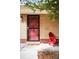 Inviting front porch area showcasing a red Adirondack chair alongside the home's brick facade at 2211 Lamar St, Edgewater, CO 80214