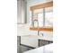 Close-up of the white farmhouse sink with stainless steel faucet and soap dispenser at 2211 Lamar St, Edgewater, CO 80214