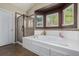 A bathroom with a soaking tub, a glass-enclosed shower, and views of nature at 10856 Parker Vista Ln, Parker, CO 80138
