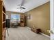 Bedroom with neutral carpet, ceiling fan, and a built in desk next to a window with a view at 10856 Parker Vista Ln, Parker, CO 80138