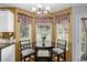 Cozy breakfast nook with a round table, two chairs, bright windows, and cheerful plaid curtains at 10856 Parker Vista Ln, Parker, CO 80138