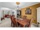 Elegant dining room featuring a wooden table, chandelier, detailed wall decor, and an open view to the living room at 10856 Parker Vista Ln, Parker, CO 80138