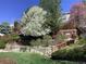 Beautiful landscaped yard featuring multi-level wood retaining walls, mature trees, and lush greenery at 10856 Parker Vista Ln, Parker, CO 80138