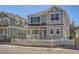 Charming two-story home with light grey siding and a white picket fence at 7998 E Vassar Dr, Denver, CO 80231